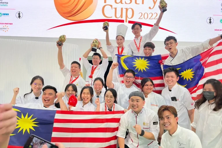APCA chefs and students celebrating with the Malaysian flag at a pastry competition