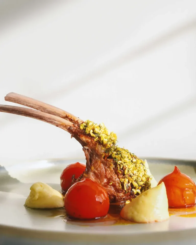Plated rack of lamb with roasted tomato and pistachio crust