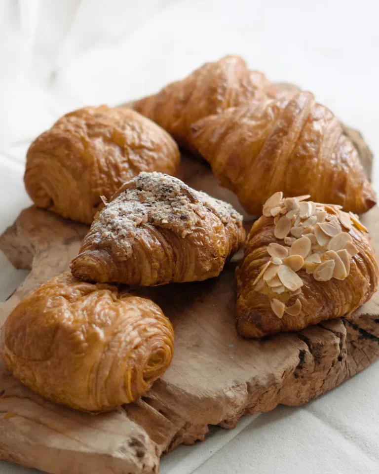 Freshly baked almond croissants on a board